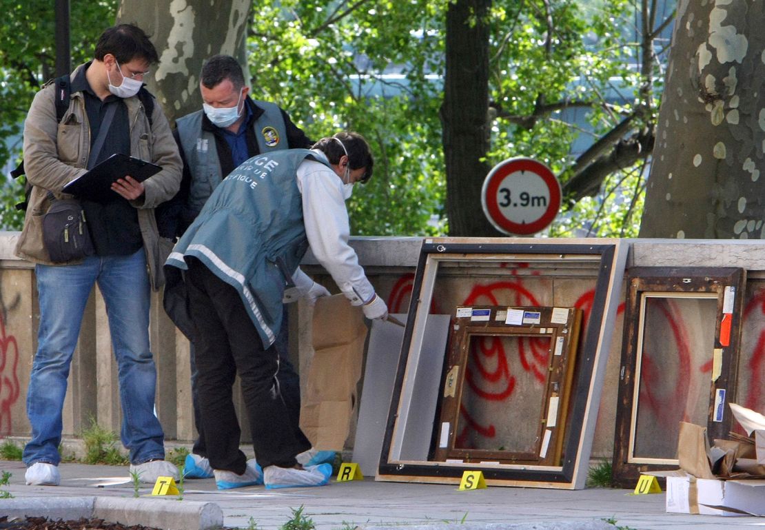 Police officers in Paris search for clues in the frames of the stolen paintings outside the Museum of Modern Art on May 20, 2010.