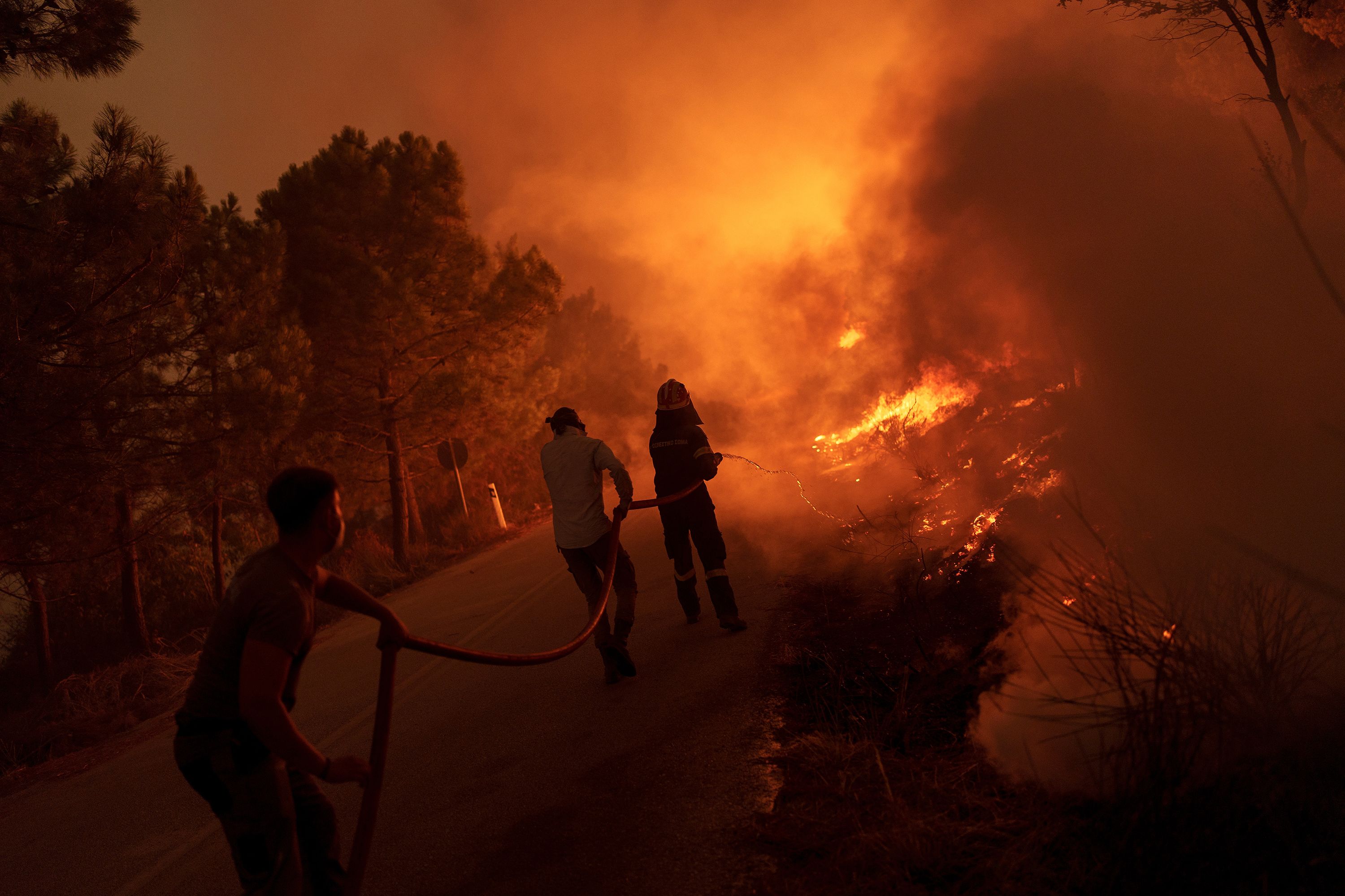 Firefighters and volunteers work to extinguish a wildfire near the Greek village of Dikella on Tuesday, August 22. Greece is struggling with dozens of wildfires as Europe swelters under yet another extreme heat wave.