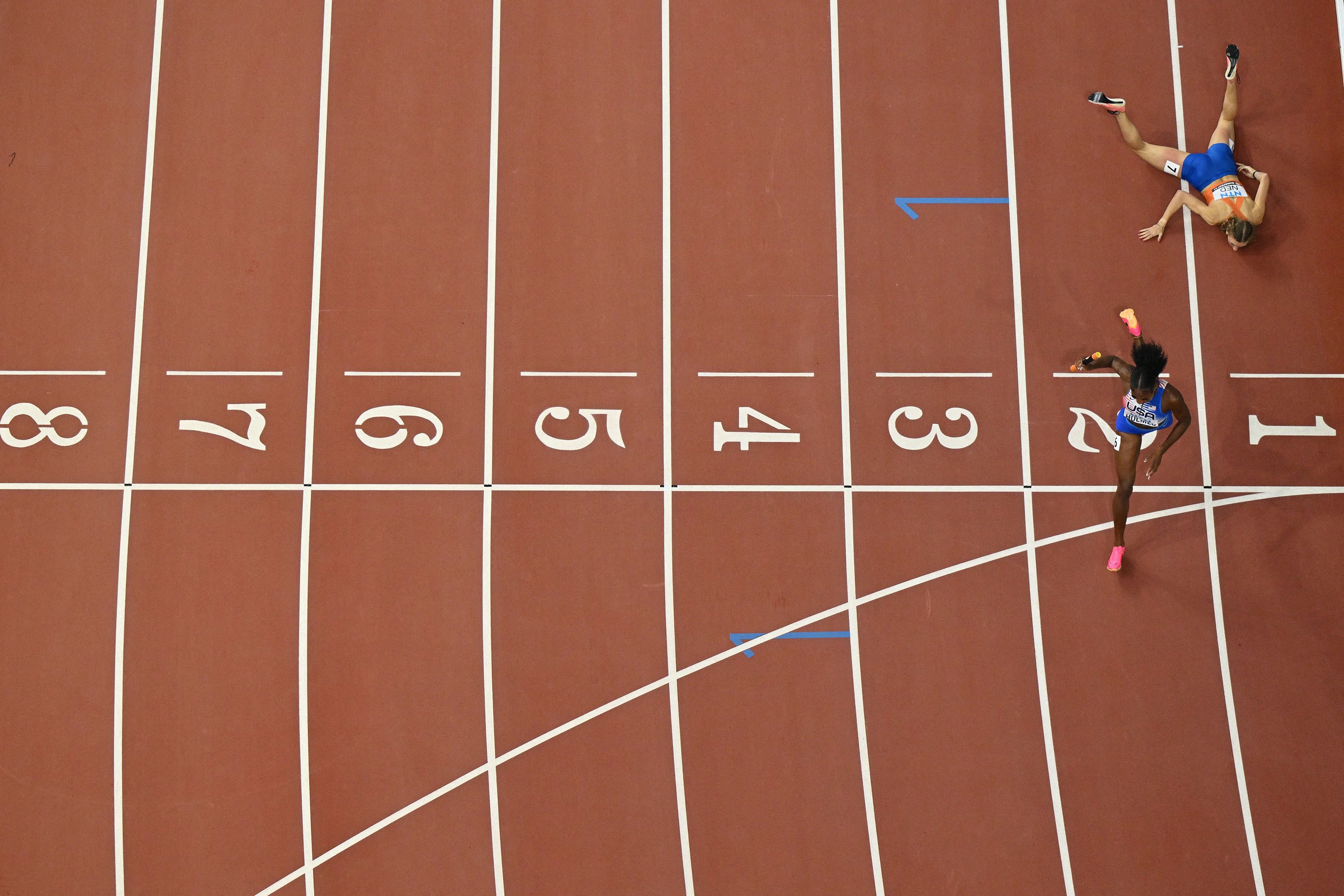 American Alexis Holmes runs past the Netherlands' Femke Bol, who had fallen just before the finish line during a mixed 4x400-meter relay at the World Athletics Championships on Saturday, August 19.