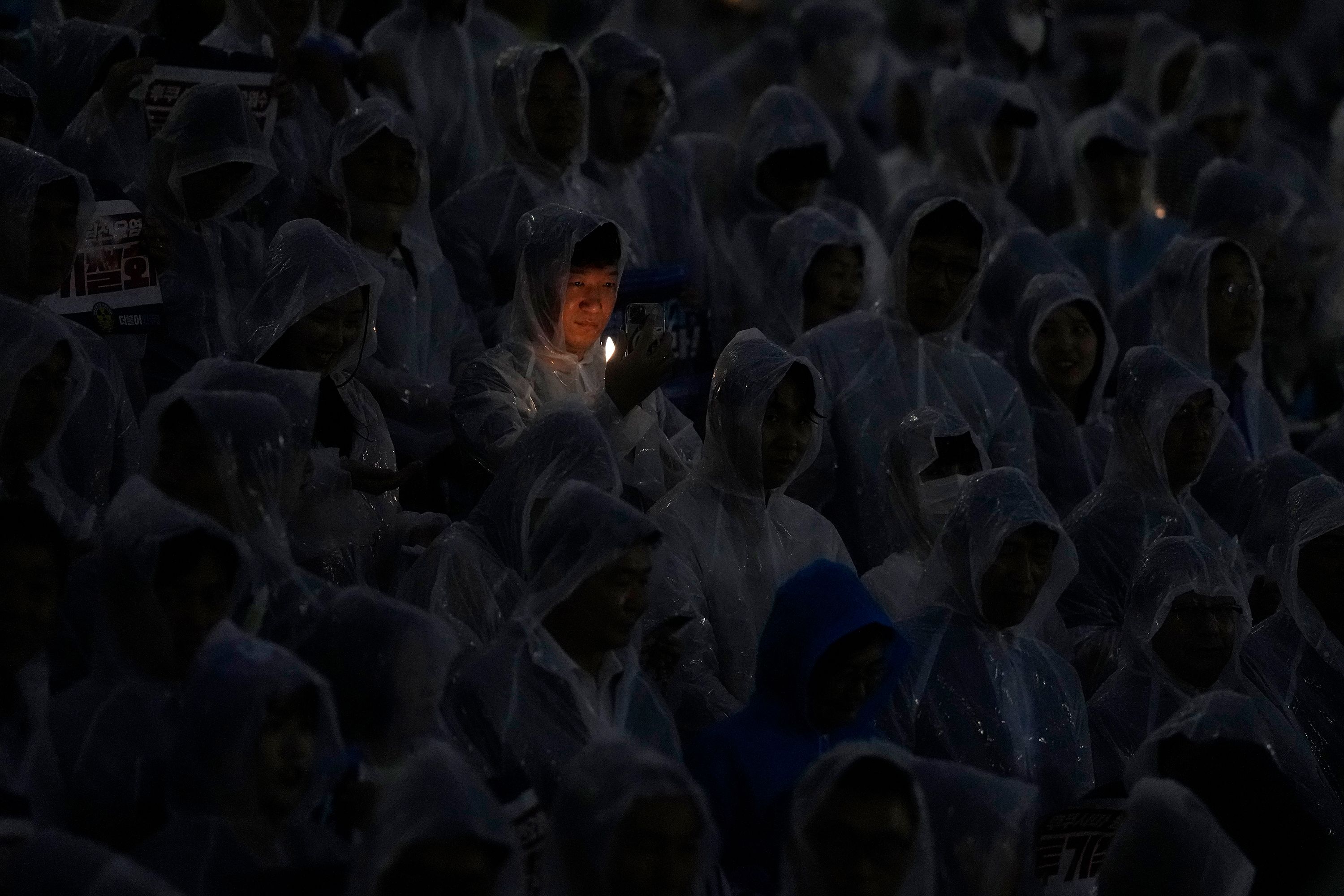 People hold electronic candles during a rally in Seoul, South Korea, on Wednesday, August 23. They were protesting Japan's decision to release treated radioactive water from Fukushima into the ocean.