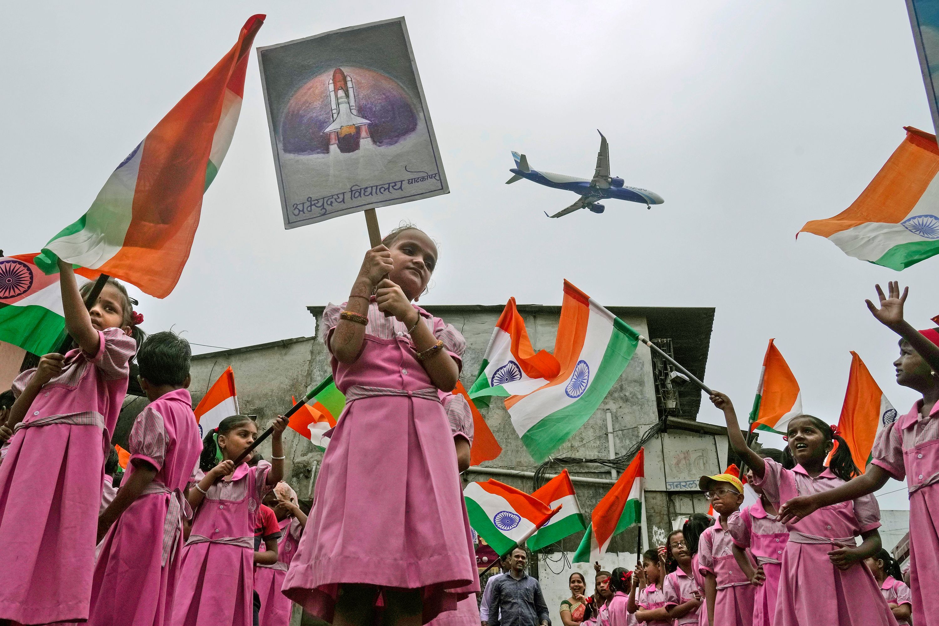 An aircraft prepares to land in Mumbai, India, as schoolchildren cheer for India's Chandrayaan-3 spacecraft on Tuesday, August 22. India successfully landed Chandrayaan-3 on the moon, becoming only the fourth nation ever to accomplish such a feat.