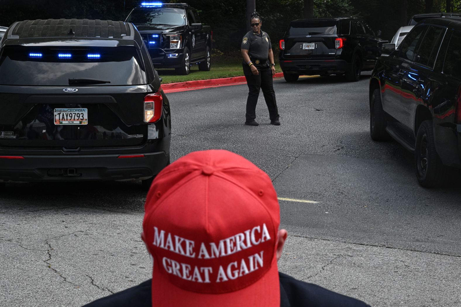 Authorities maneuver vehicles as Trump supporters line a street near the jail on Thursday.