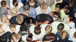 Crowd of people huddled together, overhead view - stock photo