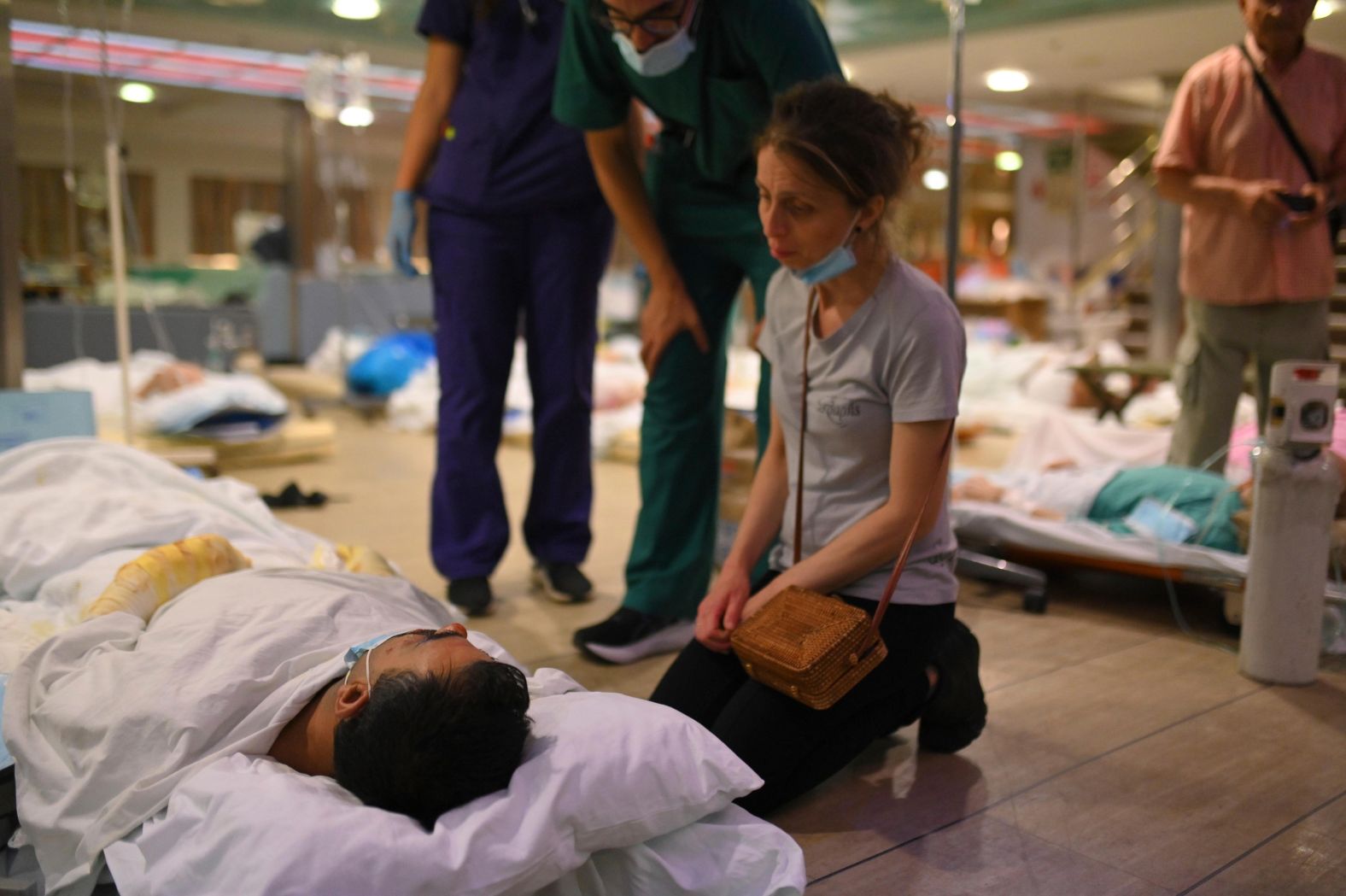 A woman sits next to a patient on the floor of a ferry boat after health authorities partially evacuated a hospital in Alexandroupolis, Greece, on August 22.