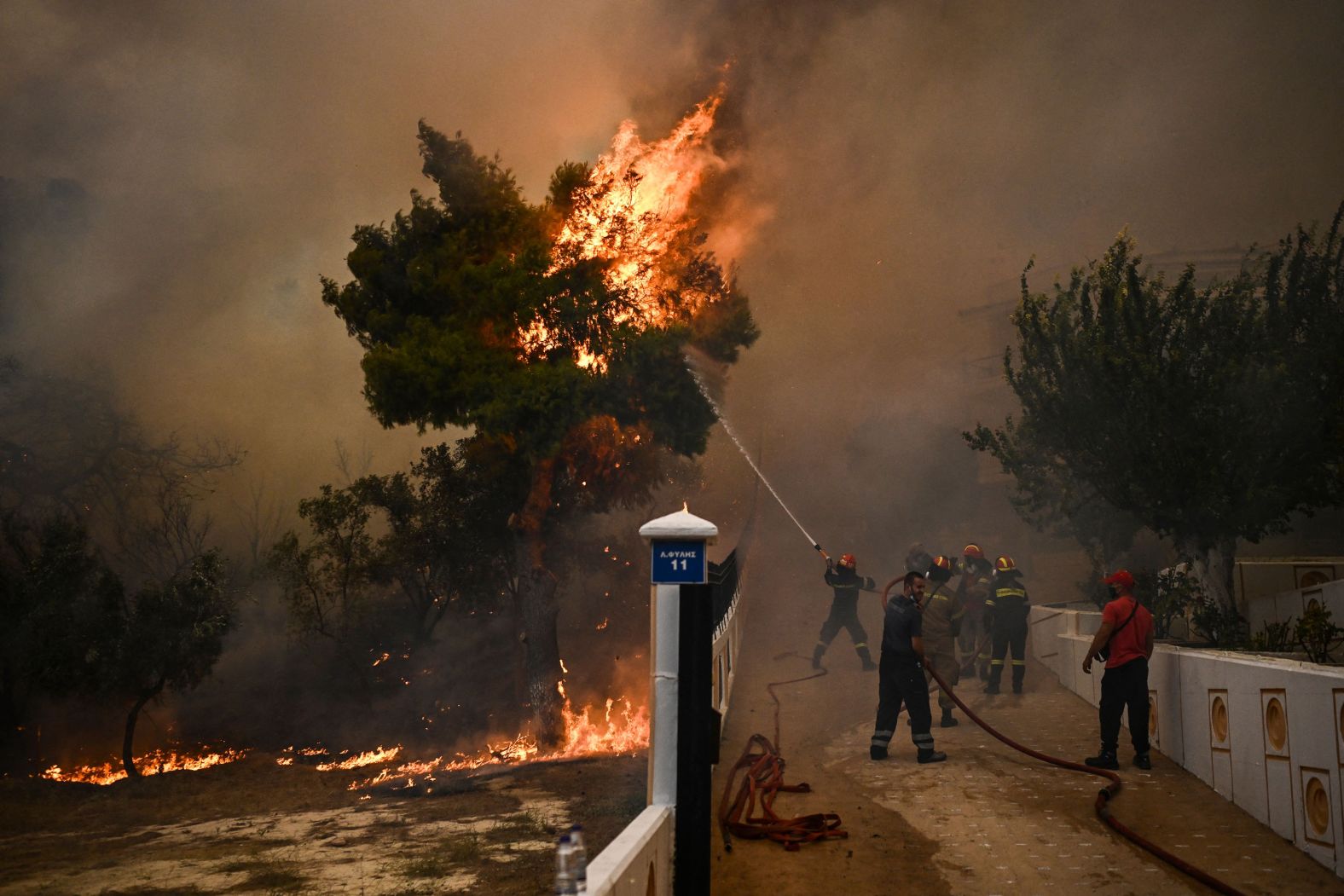 A firefighter sprays water on flames during a wildfire in Chasia on August 22.