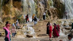 Afghan women walk by a waterfall in the Band-e Amir National Park on August 12, 2022 in Band-e Amir, Afghanistan. 