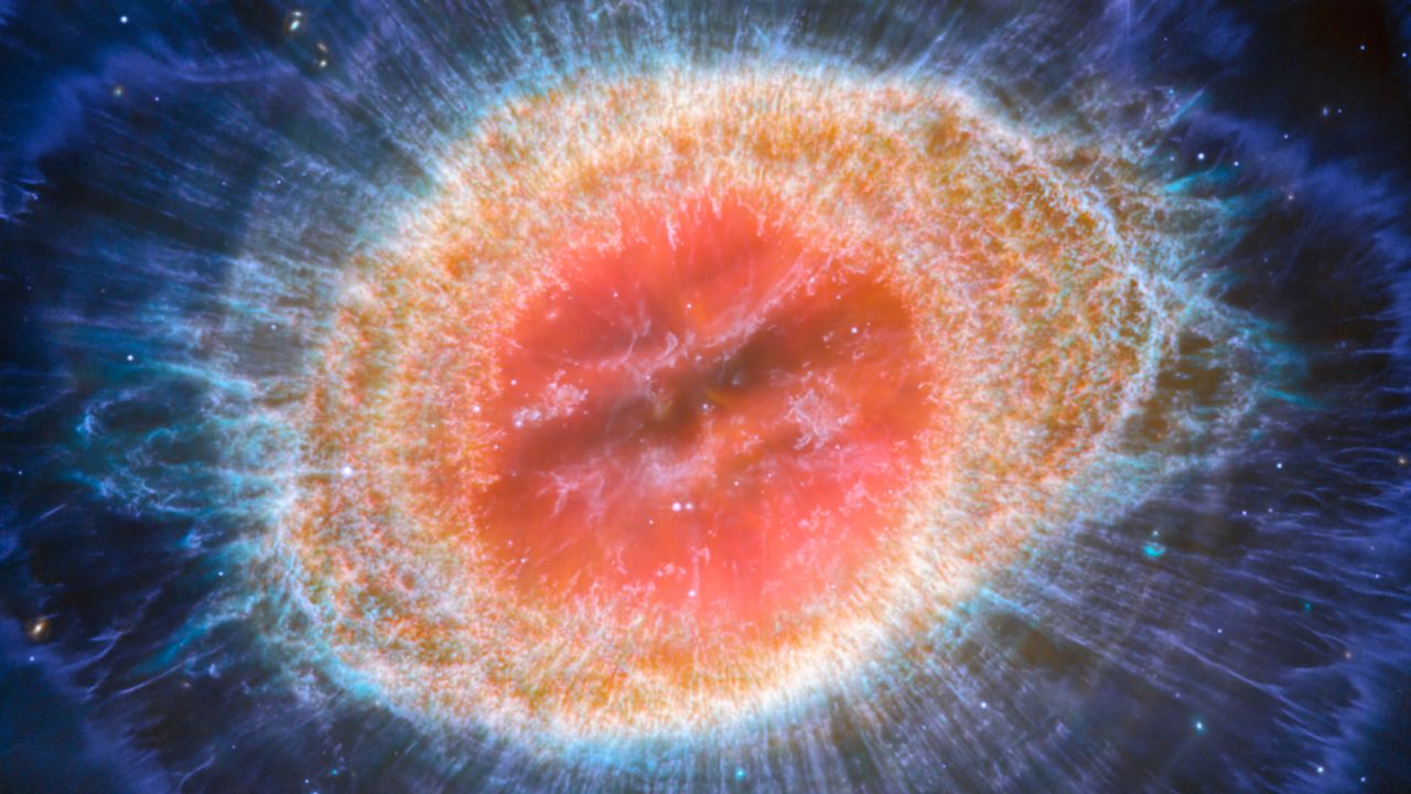 The NASA/ESA/CSA James Webb Space Telescope has captured the famous Ring Nebula in unprecedented detail. When a star runs out of fuel, it sheds its outer layers, making the Ring Nebula an ideal planetary nebula. It is also known as M57 and NGC 6720, both relatively close to Earth at approximately 2,500 light-years away. This new image provides unprecedented spatial resolution and spectral sensitivity. In particular, Webb's MIRI (Mid-Infrared Instrument) reveals special details in the concentrated features in the outer regions of the nebula's ring (right). The nebula contains about 20,000 dense globules, which are rich in molecular hydrogen. In contrast, very hot gas appears in the inner region. The main cover consists of a thin ring of enhanced emissions from carbon-based molecules known as polycyclic aromatic hydrocarbons (PAHs). About ten concentric arcs lie just beyond the outer edge of the main ring. The arcs are believed to result from the interaction of the central star with a low-mass companion orbiting at a distance between that of Earth and the dwarf planet Pluto. In this way, nebulae like the Ring Nebula reveal a kind of astronomical archaeology, as astronomers study a nebula to learn about the star that created it. (Image description: This image of the Ring Nebula appears as a distorted doughnut. The inner cavity of the nebula hosts red and orange colors, while the wide ring shows through yellow in the inner regions and blue/violet colors in the outer region) The inner region of the ring consists of individual filament elements.)