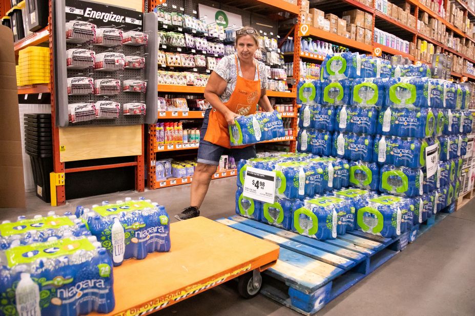 Home Depot employee Sharon Walsh fills a cart with cases of water as customers prepare for Idalia in Ocala, Florida, on August 28.