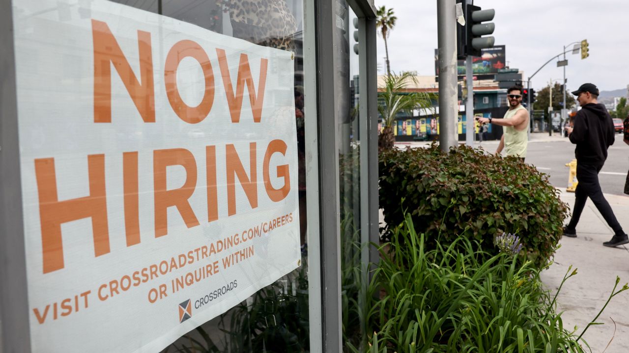 A 'Now Hiring' sign is displayed outside a resale clothing shop on June 2, 2023, in Los Angeles, California. 