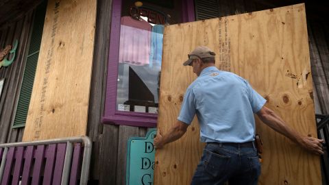 A man places plywood in front of a store ahead of the arrival of Hurricane Idalia in Cedar Key, Florida.