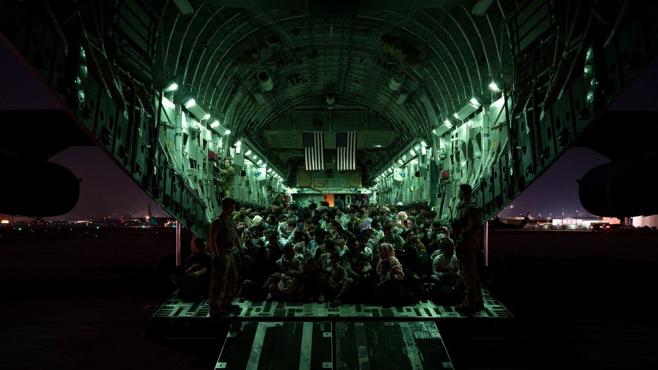 In this handout provided by the US Air Force, an air crew assigned to the 816th Expeditionary Airlift Squadron assists evacuees aboard a C-17 Globemaster III aircraft in support of the Afghanistan evacuation at Hamid Karzai International Airport on August 21, 2021 in Kabul, Afghanistan.