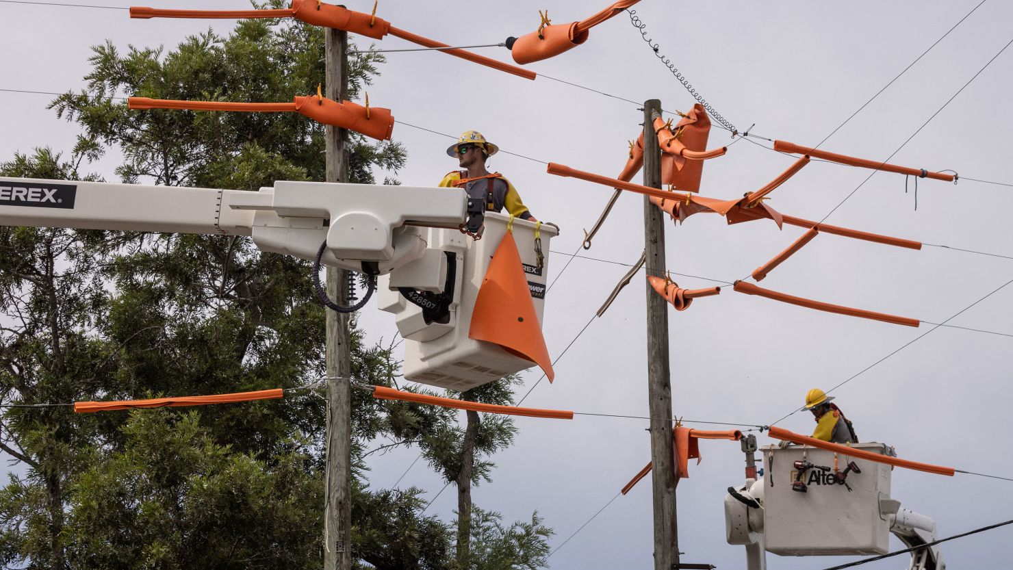 Workers secure power lines ahead of a storm. 