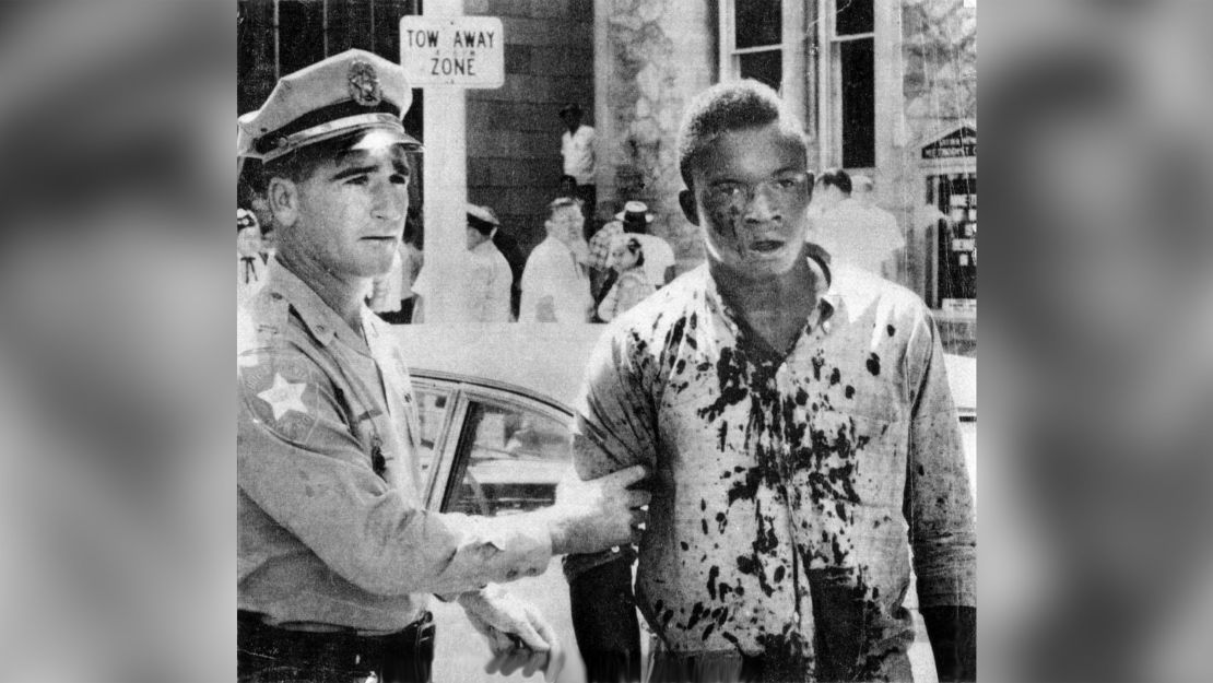 A police officer holds onto a victim of civil unrest in Jacksonville, Florida on August 27, 1960.