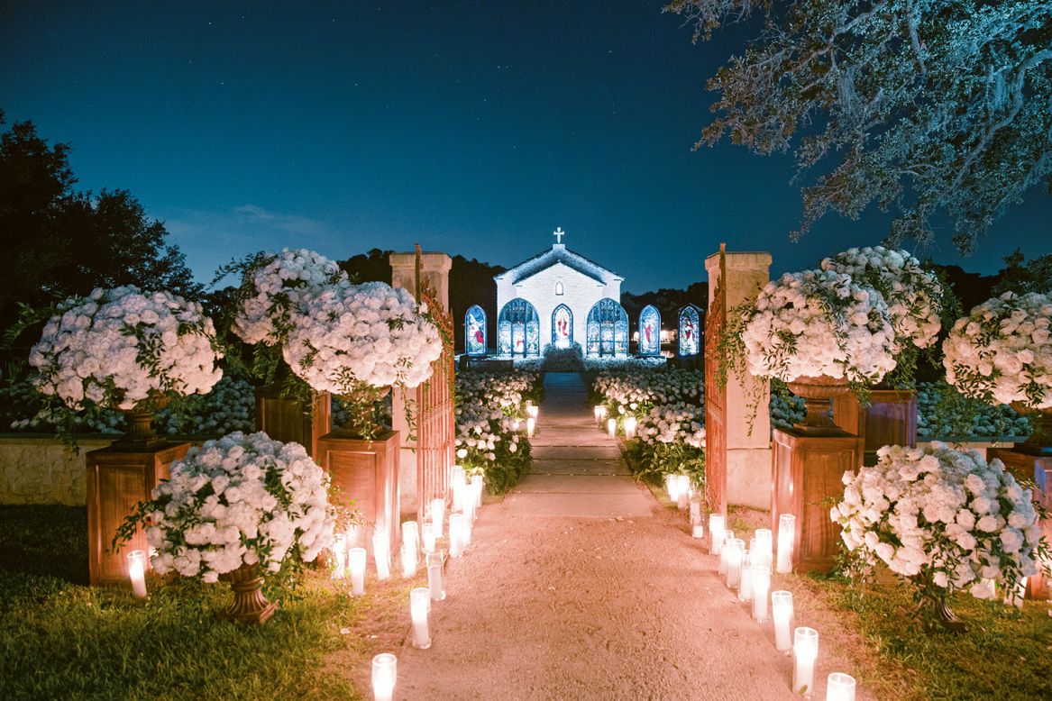 Roses, hydrangeas, and leather leaf installed around a chapel at a private wedding in Texas.