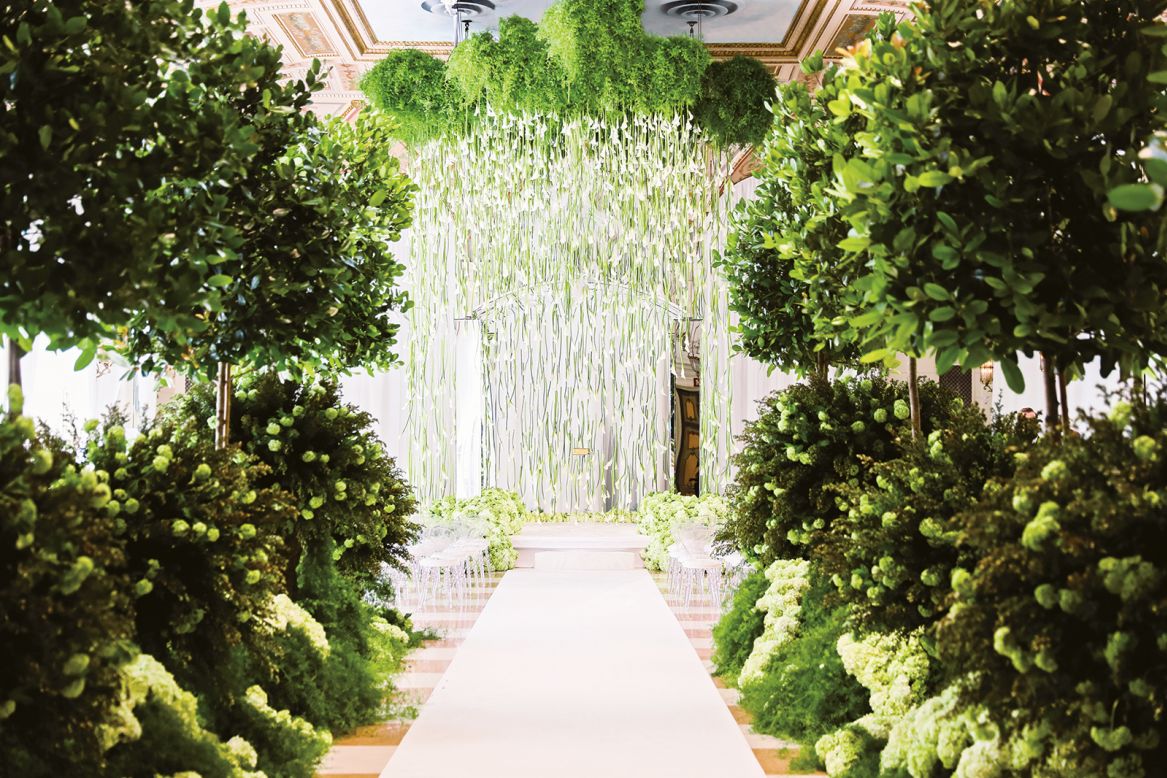 Hanging calla lilies, hydrangeas, and viburnum adorn the aisle at a private wedding in Palm Beach, Florida.