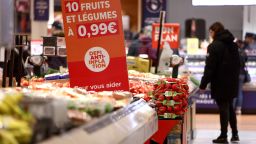 A customer looks at fruits et vegetables next to an information sign reading "10 fruits and vegetables with a price of 0.99 euro, anti-inflation challenge", at a  Carrefour hypermarket in Villeneuve-la-Garenne, in the northern suburbs of Paris, on March 29, 2023. (Photo by Thomas SAMSON / AFP) (Photo by THOMAS SAMSON/AFP via Getty Images)