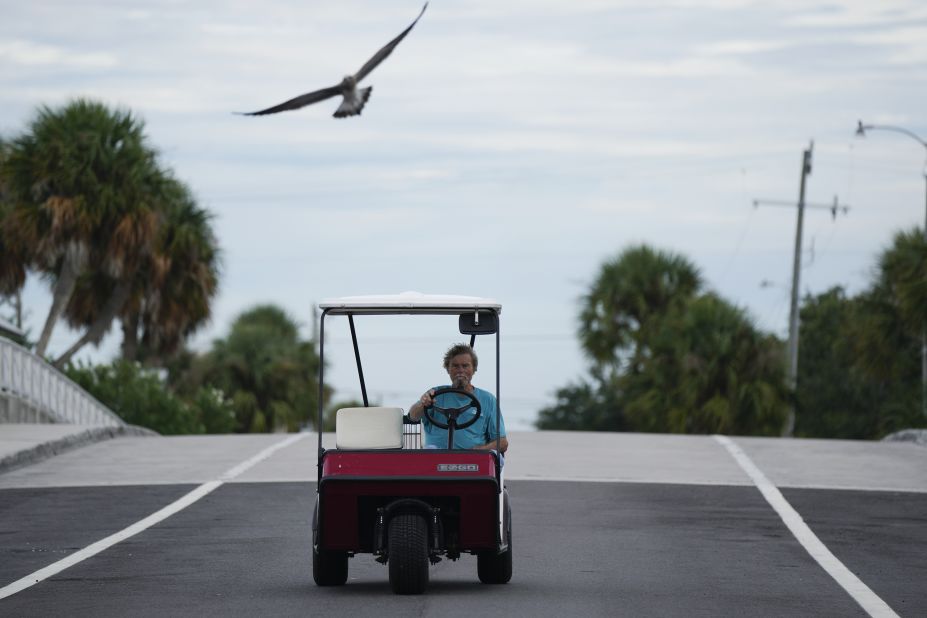 A resident drives his golf cart over a bridge in Cedar Key, Florida, on August 29.