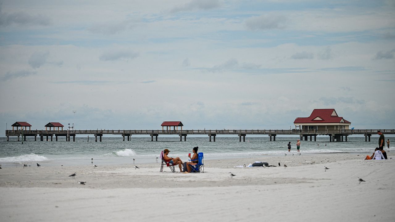People enjoy the beach in Tampa, Florida, on August 29, 2023 as the city prepares for Hurricane Idalia. Hurricane Idalia intensified Tuesday as it churned toward the west coast of Florida, triggering mass evacuation orders and flood alerts as authorities warned of life-threatening ocean surge and catastrophic destruction when the storm rages ashore early Wednesday. (Photo by Miguel J. Rodriguez Carrillo / Miguel J. Rodriguez Carrillo / AFP) (Photo by MIGUEL J. RODRIGUEZ CARRILLO/Miguel J. Rodriguez Carrillo/AFP via Getty Images)