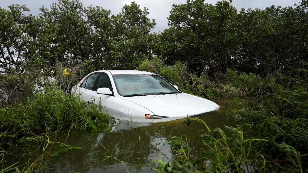 Um veículo fica parcialmente submerso quando o furacão Italia atinge Cedar Key, Flórida.