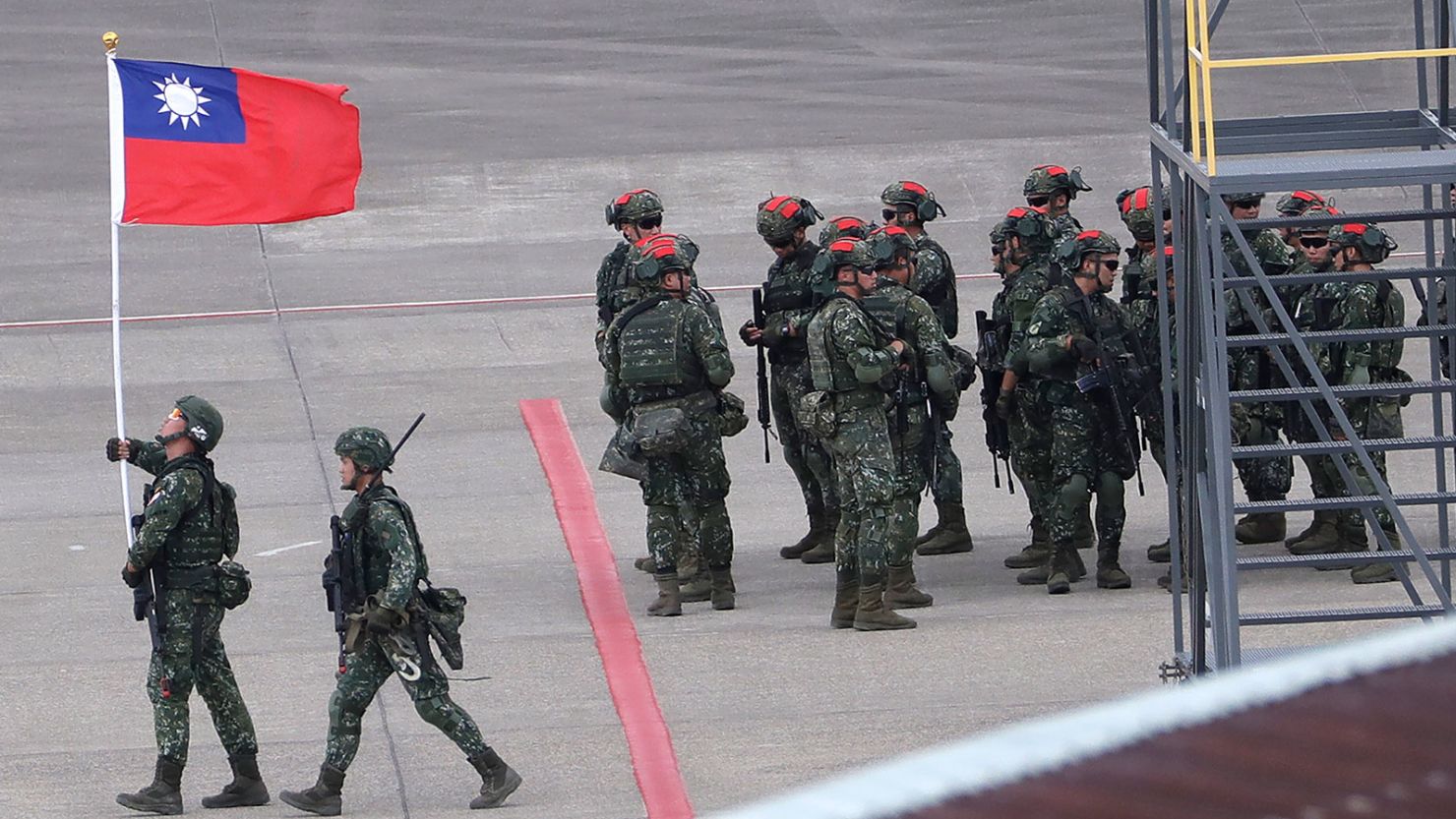 A Taiwanese soldier holds a Taiwan national flag during the annual Han Kuang military exercises at Taoyuan International Airport in Taoyuan, Northern Taiwan, July 26, 2023. The Biden administration has approved the first-ever transfer of US military equipment to Taiwan under a program typically saved for sovereign nations, according to a notification sent to Congress on Tuesday, August 29, 2023. 