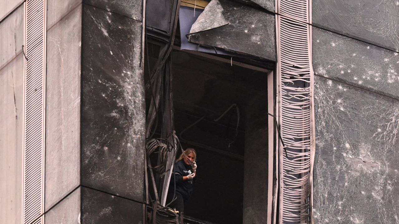 TOPSHOT - A woman inspects the damage sustained to a building of the Moscow International Business Center (Moskva City) following a drone attack in Moscow on August 23, 2023. A Ukrainian drone attack on Moscow damaged a building in a central business district, authorities said on August 23, in the sixth straight night of aerial attacks on Russia's capital region. (Photo by NATALIA KOLESNIKOVA / AFP) (Photo by NATALIA KOLESNIKOVA/AFP via Getty Images)