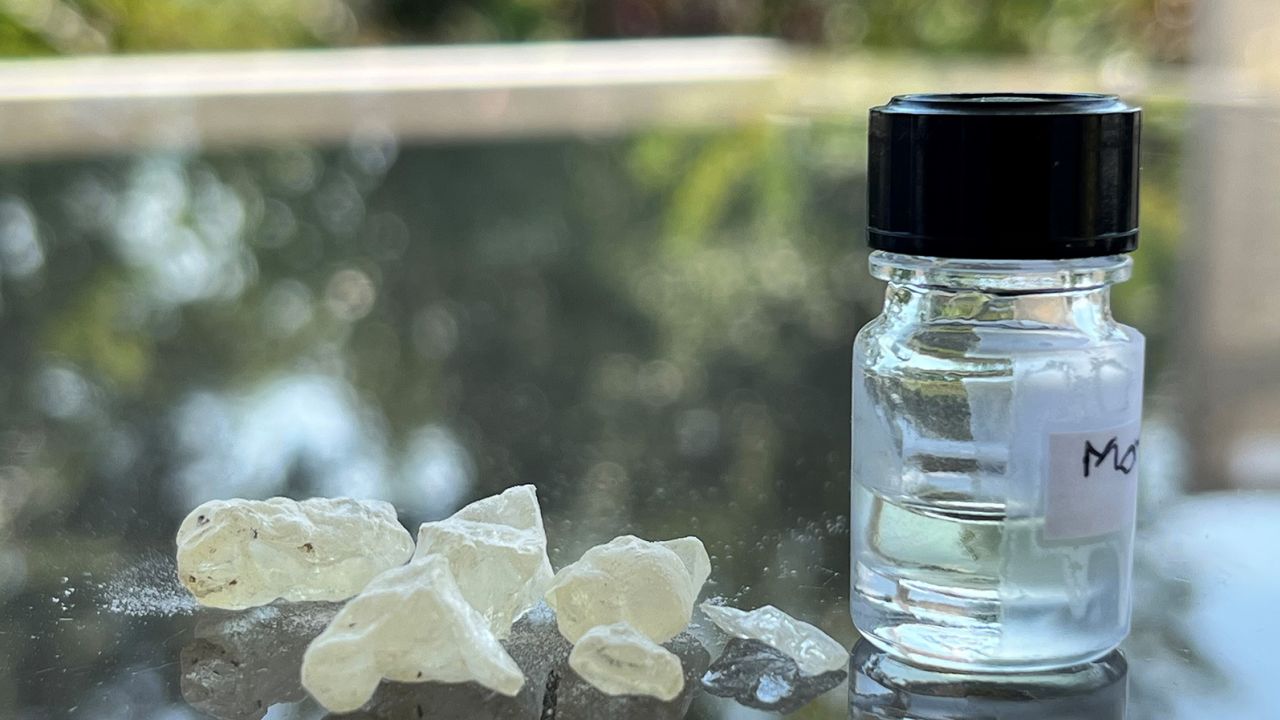 Damaro derva, mumifikacijos sudedamoji dalis, šalia senovinių kvepalų buteliuko, kurį parfumerė Carole Calvez atkūrė remdamasi moksline analize.