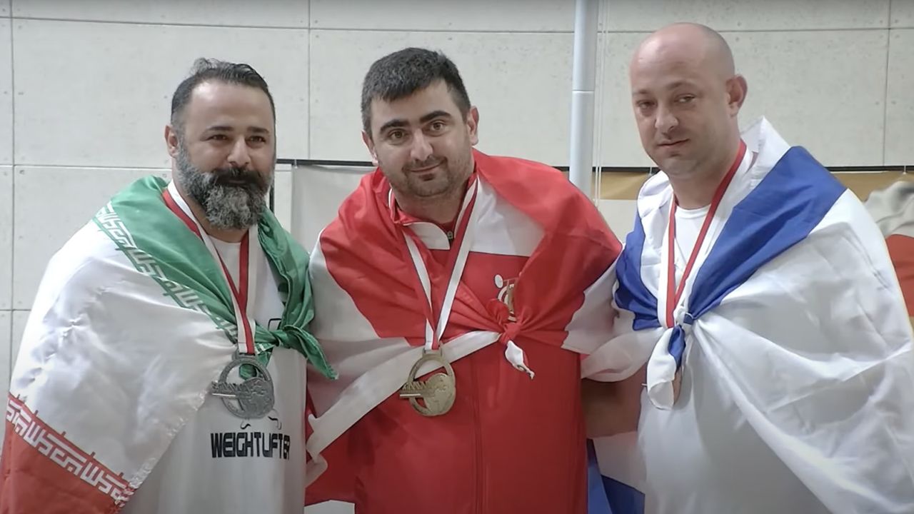 Iran has banned a weightlifter from sports for life and dissolved a sports committee after the athlete greeted an Israeli counterpart on a podium.
Mostafa Rajaei, a veteran weightlifter, finished second in his category in the 2023 World Master Weightlifting Championships in Poland and stood on a podium with an Iranian flag wrapped around him on Saturday.
On anther step of the podium stood Maksim Svirsky from Israel, who finished third.