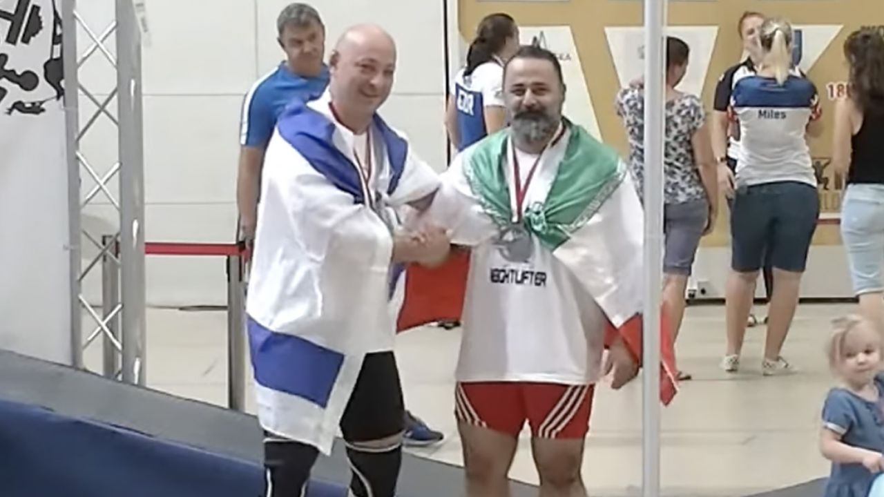 Iran has banned a weightlifter from sports for life and dissolved a sports committee after the athlete greeted an Israeli counterpart on a podium.
Mostafa Rajaei, a veteran weightlifter, finished second in his category in the 2023 World Master Weightlifting Championships in Poland and stood on a podium with an Iranian flag wrapped around him on Saturday.
On anther step of the podium stood Maksim Svirsky from Israel, who finished third.