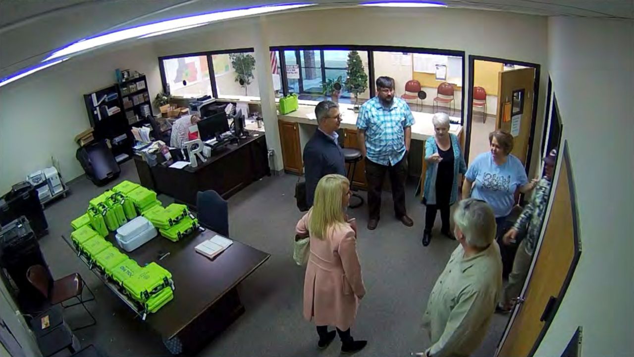 This Jan. 7, 2021, image taken from Coffee County, Ga., security video, appears to show Cathy Latham (center, long turquoise top), introducing members of a computer forensic team to local election officials. 