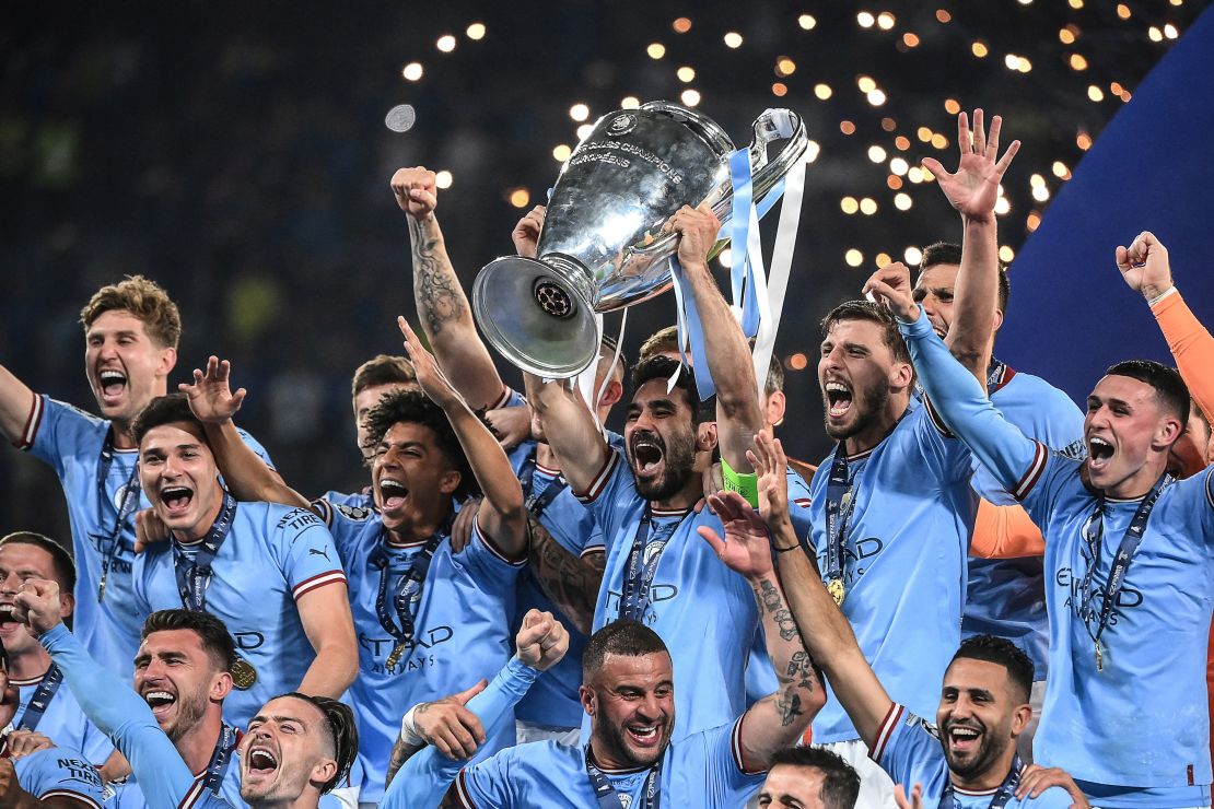 TOPSHOT - Manchester City's German midfielder #8 Ilkay Gundogan (C) lifts the European Cup trophy as they celebrate on the podium after winning the UEFA Champions League final football match between Inter Milan and Manchester City at the Ataturk Olympic Stadium in Istanbul, on June 10, 2023. (Photo by FRANCK FIFE / AFP) (Photo by FRANCK FIFE/AFP via Getty Images)