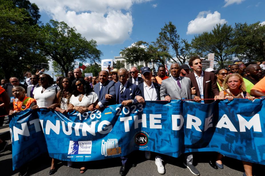 Rev. Al Sharpton, Martin Luther King III, Arndrea Waters King, Yolanda Renee King and actor Sacha Baron Cohen carry a banner during a demonstration on the 60th anniversary of the March on Washington in Washington, DC, on Saturday, August 26.