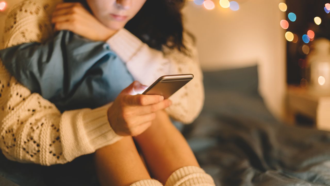 Girl texting on smartphone at home