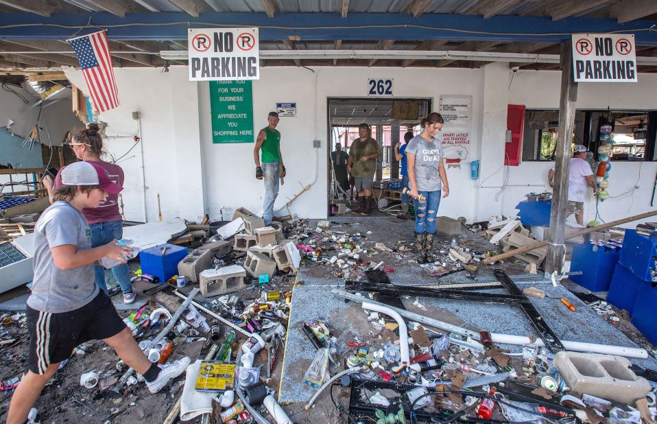 People clean debris from a damaged building in Horseshoe Beach on August 31.