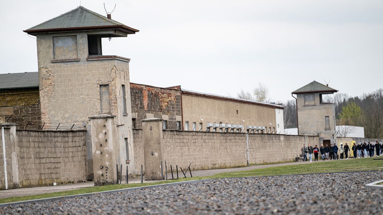 People walk the grounds of the former concentration camp at the Sachsenhausen Memorial, April 2023.