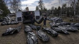 Cemetery workers unload bodies of killed civilians from a van in the cemetery in Bucha, outskirts of Kyiv, Ukraine, Thursday, April 7, 2022. (AP Photo/Rodrigo Abd)