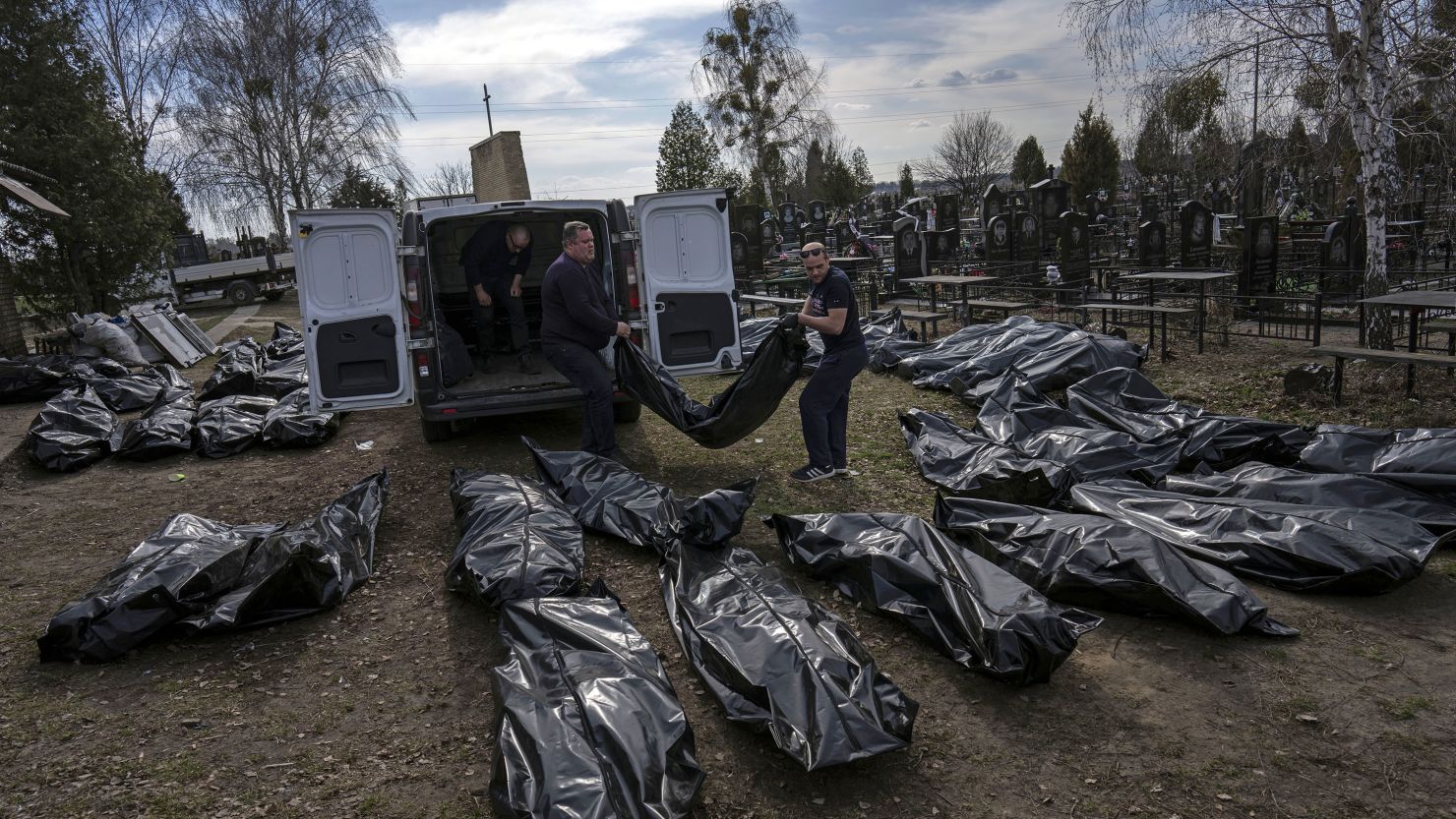 Cemetery workers unload bodies of killed civilians from a van in Bucha, Ukraine, on April 7, 2022.