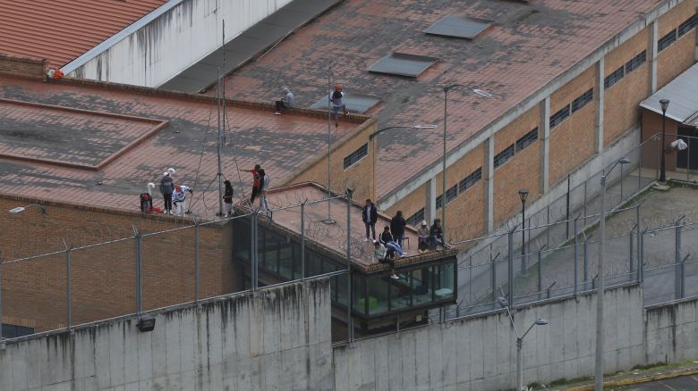 Prisoners stand on the roof of the Turi jail where dozens of prison guards and police officers have been kidnapped by the inmates, in Cuenca, Ecuador, Thursday, Aug. 31, 2023. In the last 24 hours, Ecuador has been rocked by the explosions of four car bombs and the hostage-taking of more than 50 law enforcement officers inside various detention facilities. (AP Photo/Xavier Caivinagua)