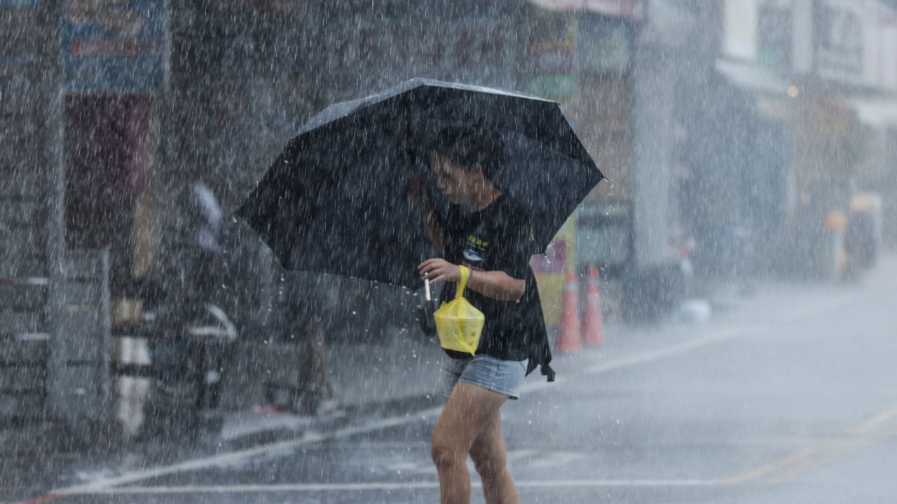 Жінка гуляє з парасолькою під час сильного дощу біля порту Су-ао в Ілані, коли Хайкуй виходить на сушу в неділю.