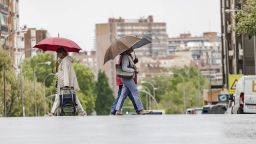 Хора се разхождат под дъжда на 2 септември 2023 г. в Мадрид, Испания. Пристигането на DANA в Испания, което се случи вчера, 1 септември, донесе дъжд и рязък спад на температурите този уикенд, когато максималните температури няма да надвишават 25 градуса в големи райони на север и вътрешността на полуострова, поради атмосферните нестабилност. По същия начин влизането на тази DANA ще отбележи началото на метеорологичната есен. Днес е денят, в който валежите ще се засилят, придружени на места дори с бури и градушки, като не са изключени и наводнения. 02 СЕПТЕМВРИ 2023 г. Carlos Luján / Europa Press 09/02/2023 (Europa Press чрез AP)