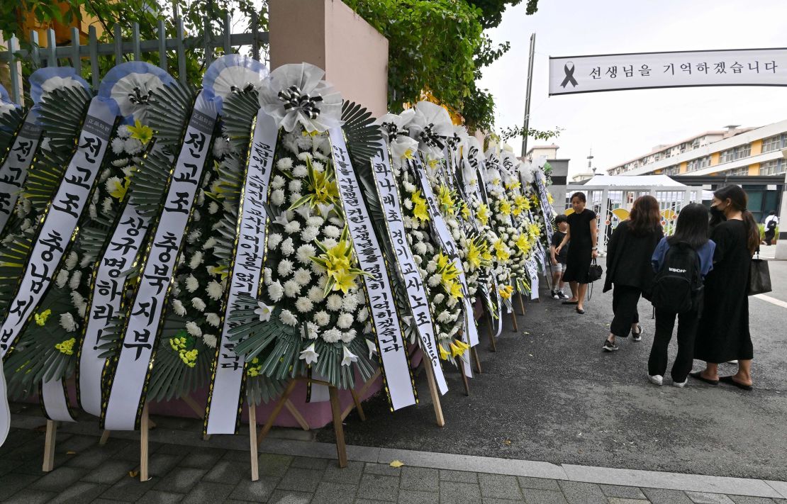 7月に教師が自殺したとみられる事件を受け、9月4日、ソウルの小学校前で花輪を手向ける追悼者ら。