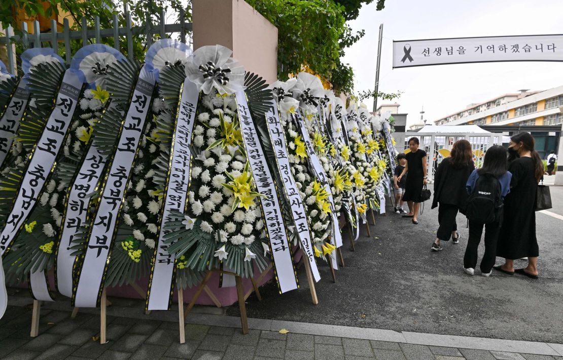 Mourners pass funeral wreaths in front of an elementary school in Seoul on September 4, following the apparent suicide of a teacher in July.