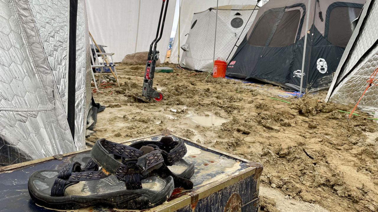 Para sandałów Deva leżała na skrzyni pośrodku namiotów po tym, jak ulewny deszcz zamienił festiwal Burning Man w błoto. 