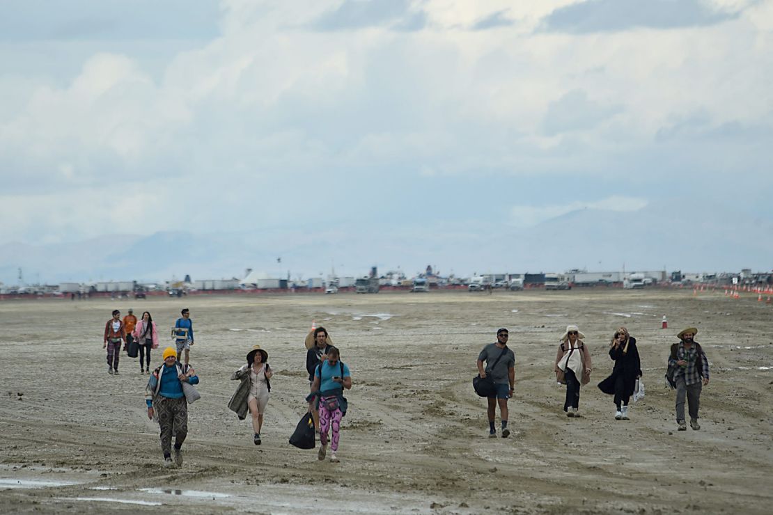 People walk off the playa out near the Burning Man site on the Black Rock Desert in northern Nevada on Sunday. 
