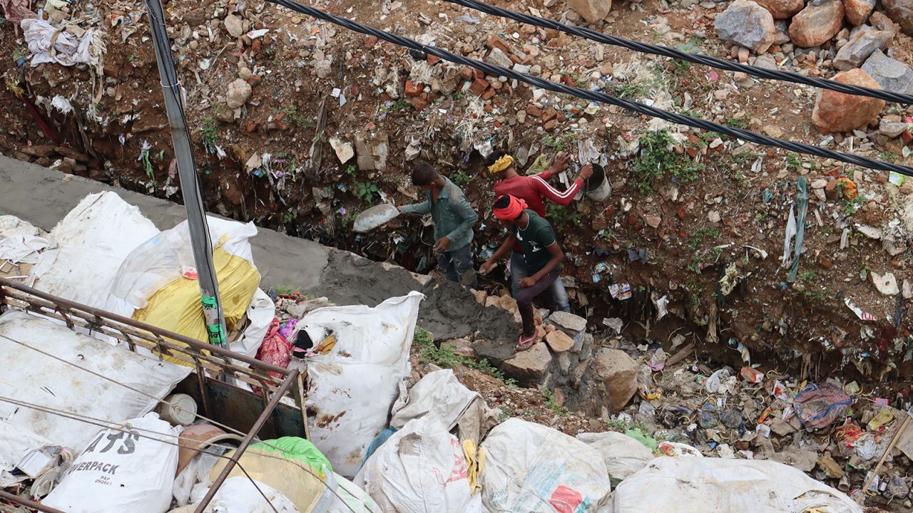 Workers build a wall near Savita's home. 
