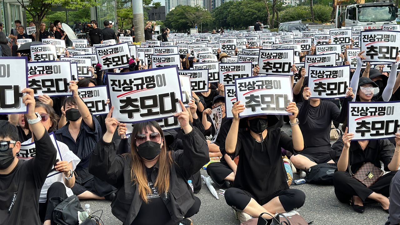 South Korean teachers holding signs that call for 