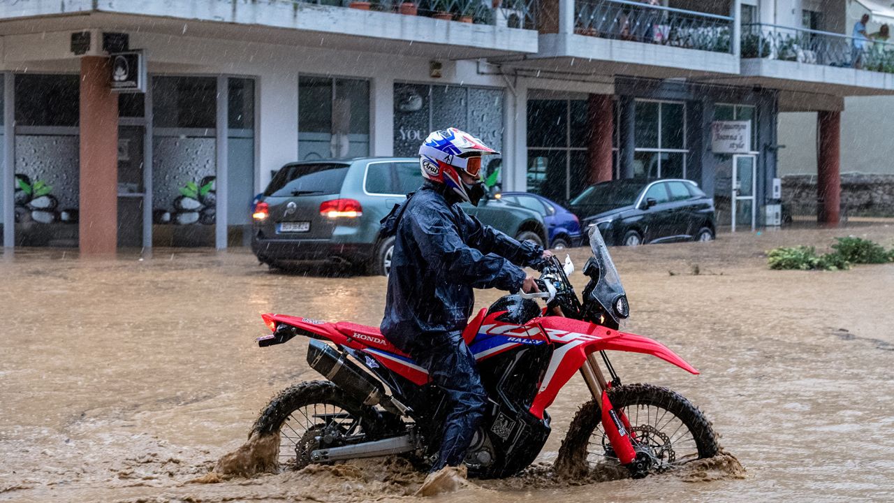 A man drives his bike in rising waters, during a storm in the city of Volos, Greece, September 5, 2023. 