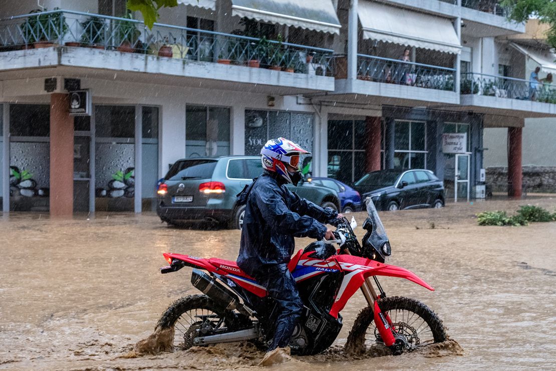 A man drives his bike in rising waters, during a storm in the city of Volos, Greece, September 5, 2023. 