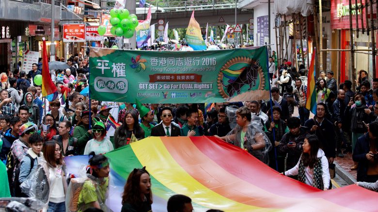 Participants of Hong Kong's annual pride parade walk through the streets with a large rainbow flag on November 26, 2016. 