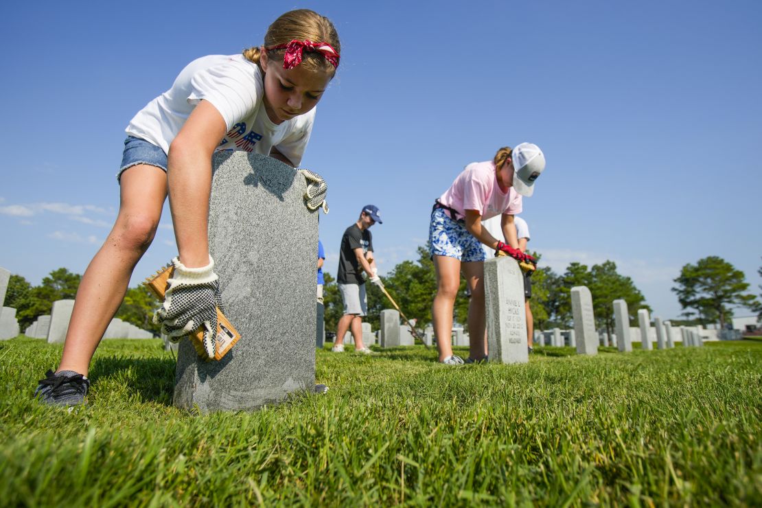 Volunteers scrub headstones and help with maintenance efforts at Houston National Cemetery Saturday, Sept. 10, 2022.