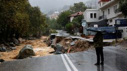A person stands on a road which collapsed due to the impact of storm Daniel, near a nursing home in the city of Volos, Greece, September 6, 2023. REUTERS/Louisa Gouliamaki
